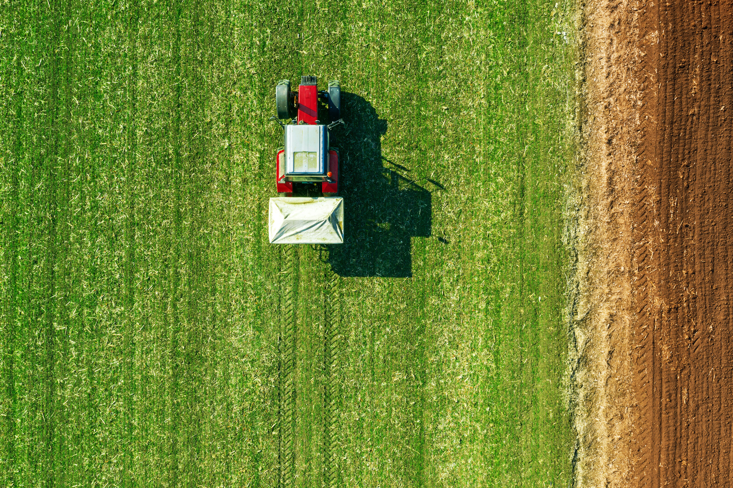Agricultural tractor fertilizing wheat crop field with NPK Agricultural tractor fertilizing wheat crop field with NPK