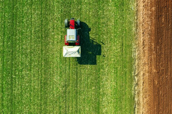 Agricultural tractor fertilizing wheat crop field with NPK Agricultural tractor fertilizing wheat crop field with NPK
